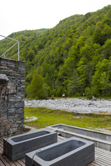 Thermal bath tubs with a view of the river and Swiss nature. Nobody inside, frontal view