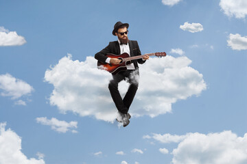 Man playing an acoustic guitar and sitting on a cloud