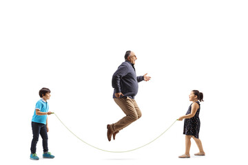 Full length profile shot of mature man skipping a rope with children