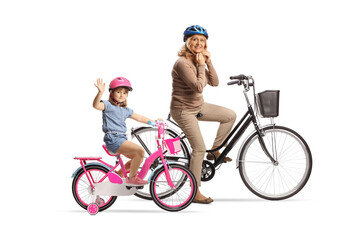 Girl and a woman on bicycles wearing helmets