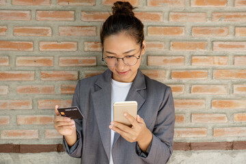 Businesswoman holding and use credit card to online shopping from home with smartphone