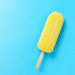Close up of a yellow popsicle on the light blue background. 水色背景上の黄色のアイスキャンディのクローズアップ