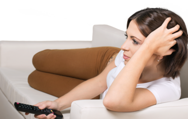 Woman Lying on the Couch Using a Remote Control