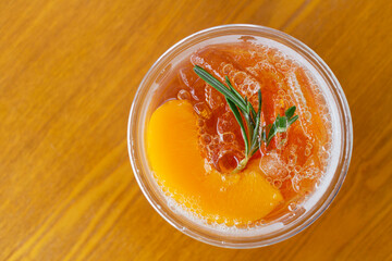 Top view, cold drink, peach tea with ice, arranged on a wooden table