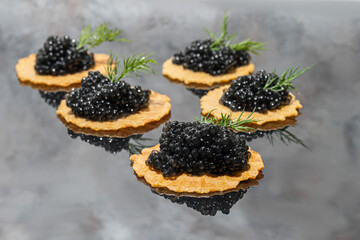 Black caviar in tartlets on a dark background. Healthy food concept.