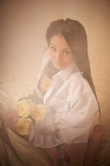 Young beautiful woman in black lace and white shirt in boudoir or bed room near white transparent...