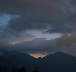 orange sunset behind mountains and a blue cloudy sky