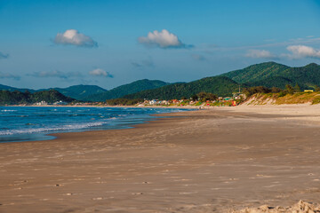 Sand beach and blue ocean with surfing waves in Brazil