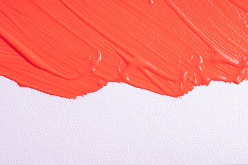 Smear of lipstick, lip gloss, paint, nail polish on a white paper canvas background. Bright red cosmetic product brush stroke sample. Textured red oil paint brush stroke.