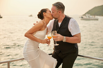Fototapeta couple drinking and kissing in luxury yacht obraz