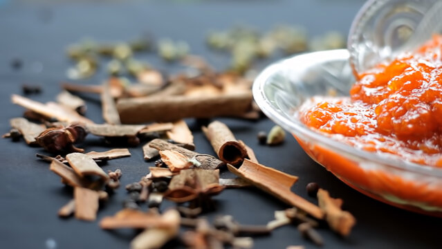 Famous Indian dessert sweet dish in a glass bowl on a jute bag's surface i.e. Murabba or Murba along with entire constituents of it on the surface.Made of Mango.