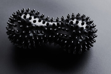 Black ball for relaxing muscle massage isolated on black background. Myofascial release inventory. Sports and recovery, yoga, self-massage concept