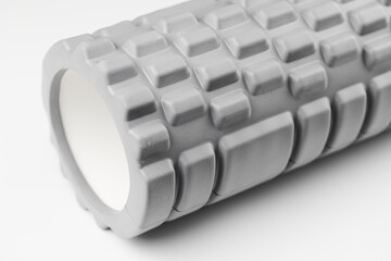 Gray foam roller for muscle relaxing massage isolated on white background. Myofascial release concept. Sports and recovery, yoga, self-massage
