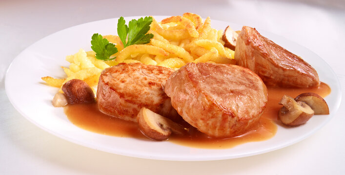 Schweinefilet mit Schupfnudeln auf weissem Teller
