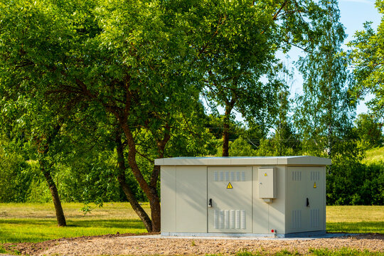 Electric high voltage distribution box in a public park under a green trees