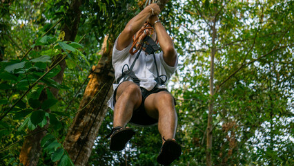 Naklejka na ściany i meble Zip line with green vegetation in the background at Tad Fane Waterfall, Pakse loop, Laos