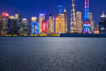 Asphalt road and city skyline with modern buildings in Shanghai at night, China.