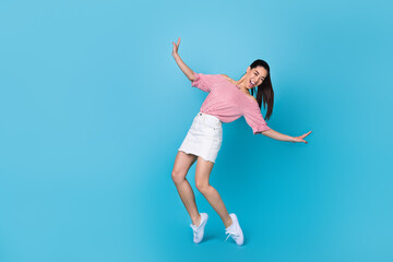 Fototapeta na wymiar Full body photo of young korean girl stay tiptoes falling danger careless celebrating posing new outfit isolated on blue color background