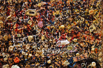 Background Texture illustration. brick wall covered in used chewing gum with lovers autographs. sticked used bubble gums and scraps of love notes