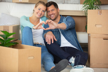 beautiful couple moving to a new house showing heart symbol