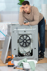 disappointer man repairing washing machine