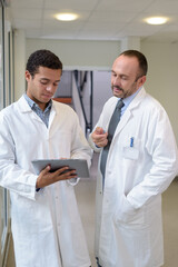 men in white coat using tablet