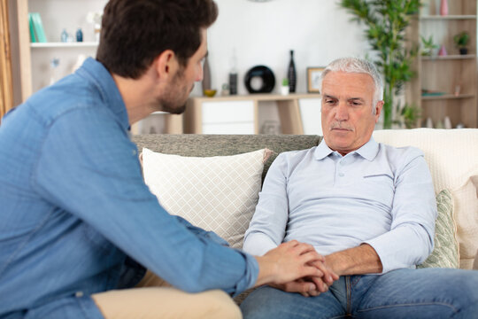 two men on sofa talking having important conversation