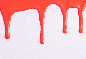 Close up of red paint drops on white paper background. Red nail polish. Sample of makeup.
