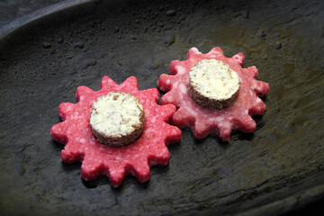 Imitation of gears carved from dry-cured sausage, cheese, bread and butter. An allegory on the theme of the combination of tastes of proteins, zhers and carbohydrates