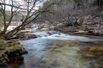 Fotografía de un paisaje impresionante: Una imagen panorámica que muestra las majestuosas montañas de La Pedriza y su río serpenteante en primer plano. 