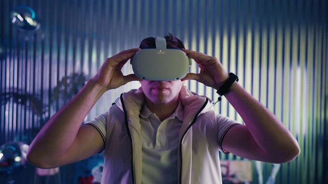 Man puts on VR glasses and drags finger to select game on virtual menu