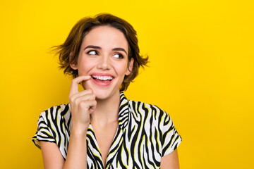 Portrait of good mood woman with short hairstyle wear striped blouse look empty space finger lip...
