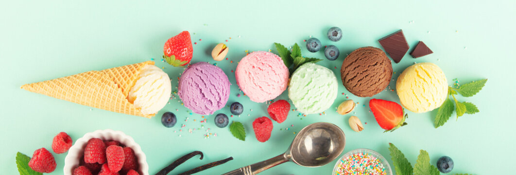 Flying ice cream balls and ingredients on pastel light blue background
