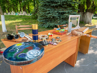 Handmade musical instruments: tambourine, bells on wooden table in park