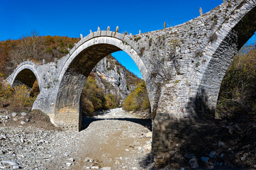 View of the traditional stone Kalogeriko or Plakida Bridge in Epirus, Greece in Autumn.