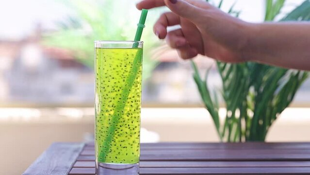 Refreshing drink with basil seeds. Detox cocktail. A woman's hand takes a drink with basil seedsA chia seed drink . Healthy food. Summer drinks.