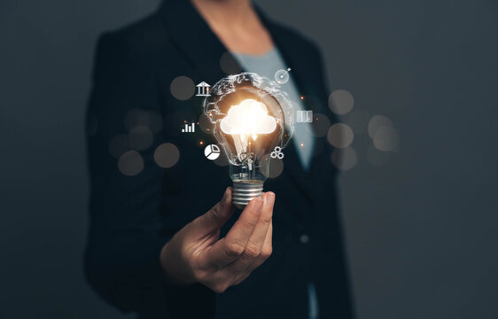 Businessman holding a light bulb. The concept of generating ideas at work. New ideas. Ideas for managing financial systems and online marketing with cloud technology to link data online