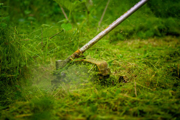 Caucasian Gardener working man Manual hand grass cutter  Weed Cutter or Power Weeder or Brush Cutter Lawn Mowe  Gasoline close up.