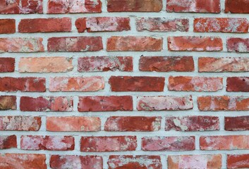 Naklejka premium Wall with red bricks and white grout. Background.