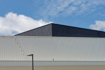 Obraz premium Minimalistic photo of an exterior of a modern tin building with a sky in the background 