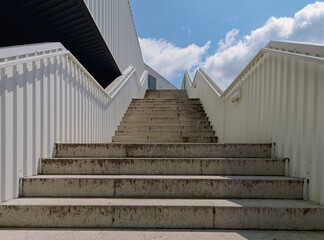 Low-angle view of a staircase on the exterior of the modern building with a sky in the background