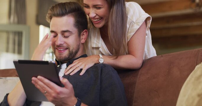 Happy couple on couch with tablet, embrace and internet, social media post or meme on website for happiness. Online search, man and woman on sofa with smile, love and relax in living room hugging.