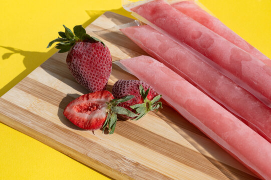 Ice cream in a bag with strawberries, sweet frozen homemade. Brazilian Dindin, chup-chup