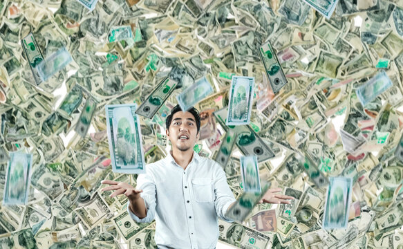 shock and Excited surprised handsome asian man with money rain on background in rich man lucky concept
