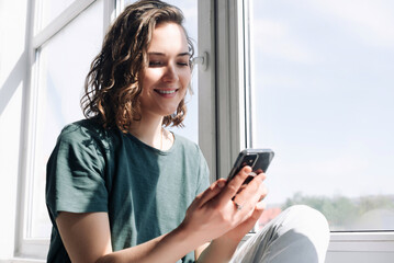 Connected in Solitude: A Young Woman Embraces Technology for Communication and Connection While Practicing Social Distancing at Home