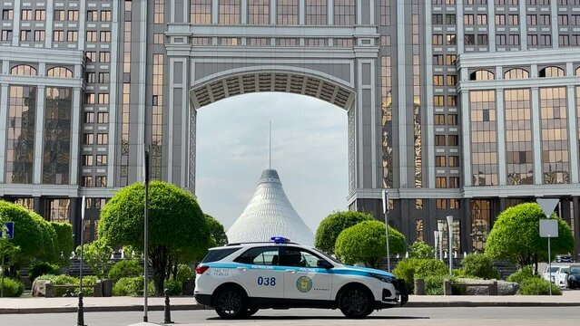 Astana, Kazakhstan, May 2023. View of Khan Shatyr. A police patrol car passes by on the road.