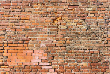 Naklejka premium Old brick wall background, brick wall texture, structure. old broken brick, cement joints, close-up. crumbling from old age.