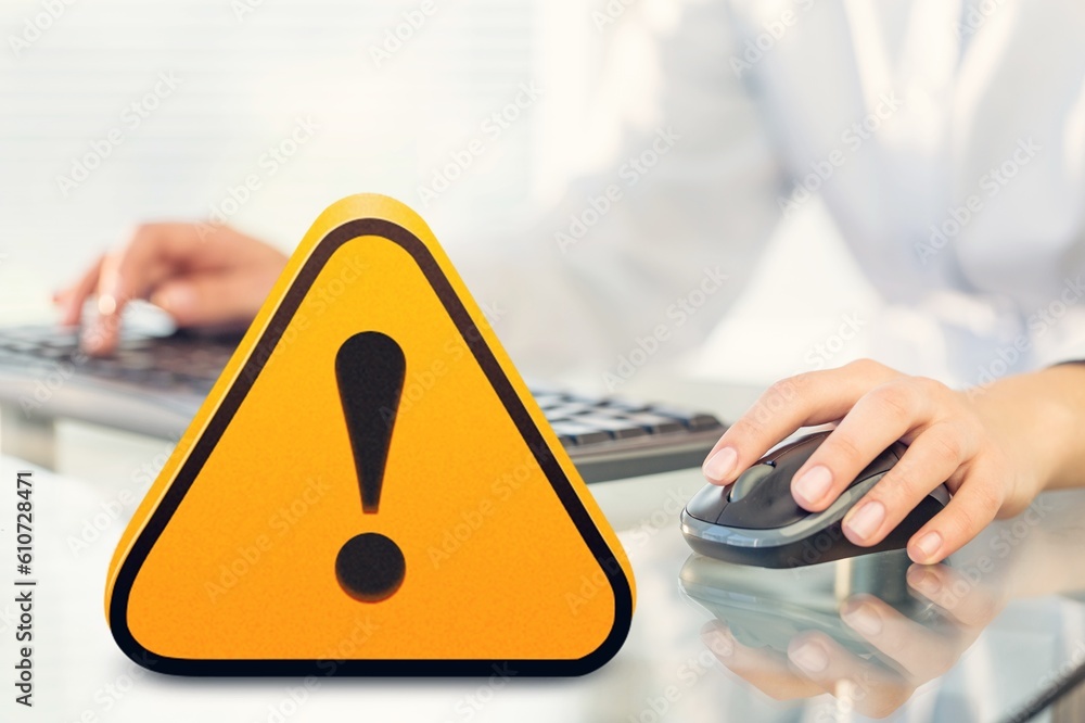 Poster warning yellow sign on table with computer