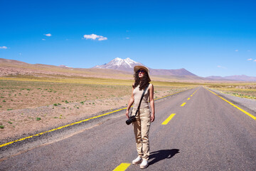 Fototapeta premium portrait full length woman photographer hiker walking on the road of San Pedro de Atacama