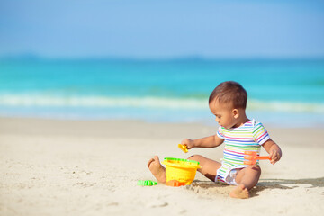 Baby playing on beach. Children play at sea.